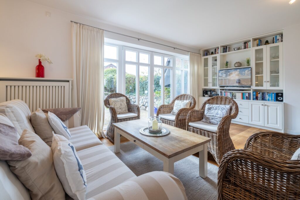 Wohnbereich mit Sofa und Stühlen in Ferienwohnung auf Sylt