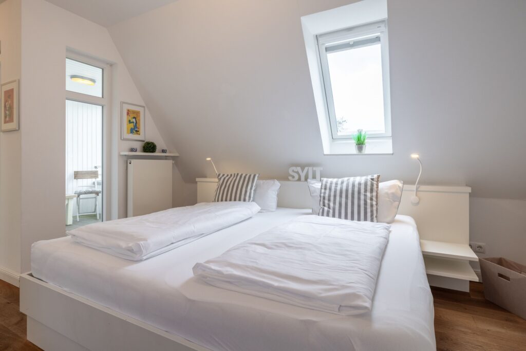 Doppelbett unter Dachfenster in Ferienwohnung auf Sylt